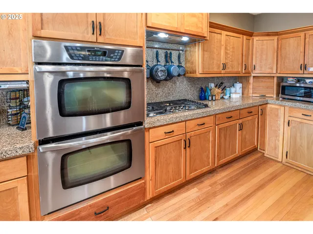 a kitchen with stainless steel appliances granite countertop a stove a microwave and a sink