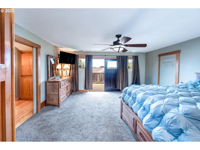 a spacious bedroom with a large bed and a chandelier