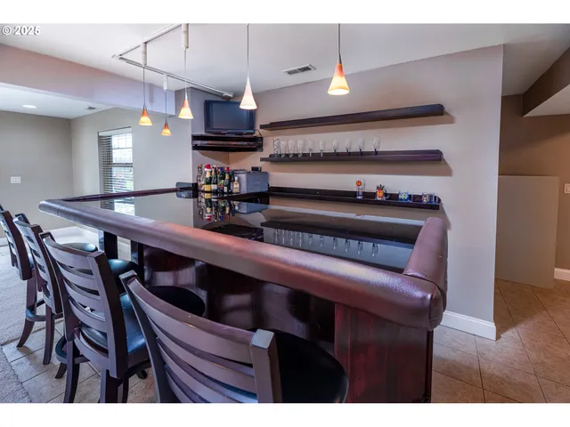 a kitchen with stainless steel appliances kitchen island a table and chairs in it