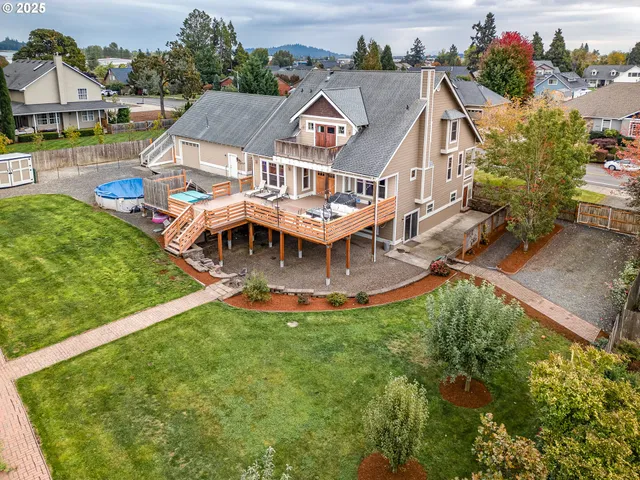 an aerial view of a house with swimming pool and a yard
