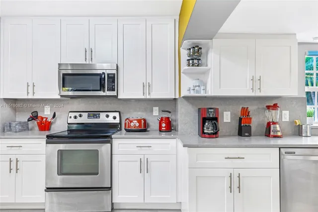 a kitchen with white cabinets and stainless steel appliances