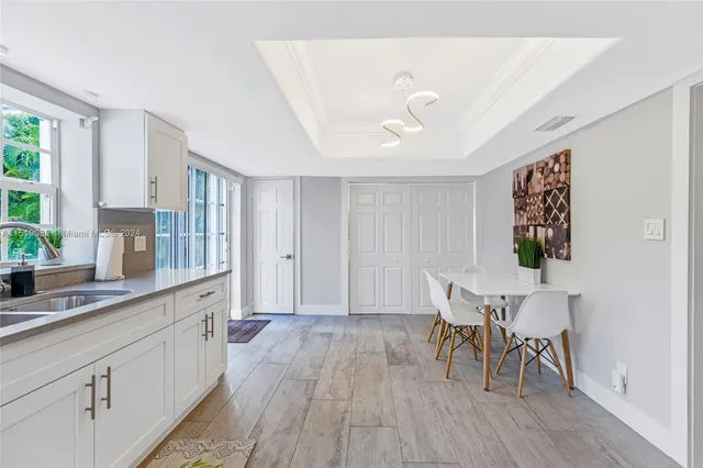 a hallway with a dining table chairs and wooden floor