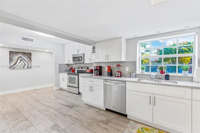 a kitchen with granite countertop white cabinets and white appliances