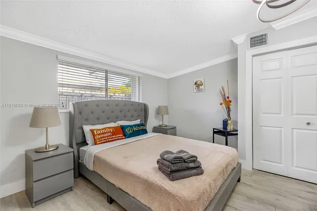 a bedroom with a bed and a lamp on dresser