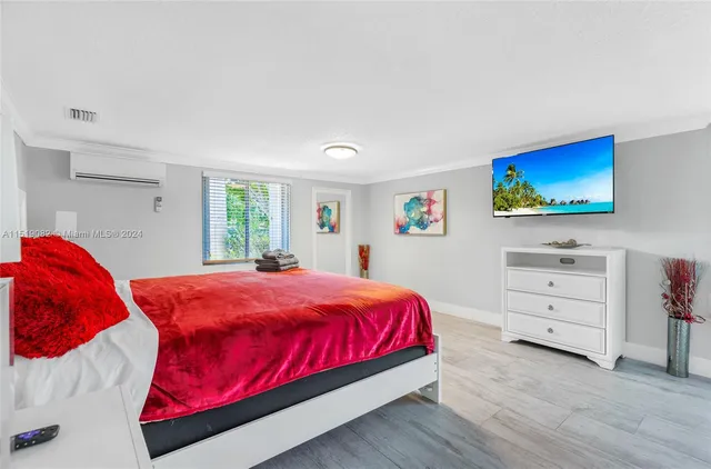 a bedroom with a bed and a flat screen tv