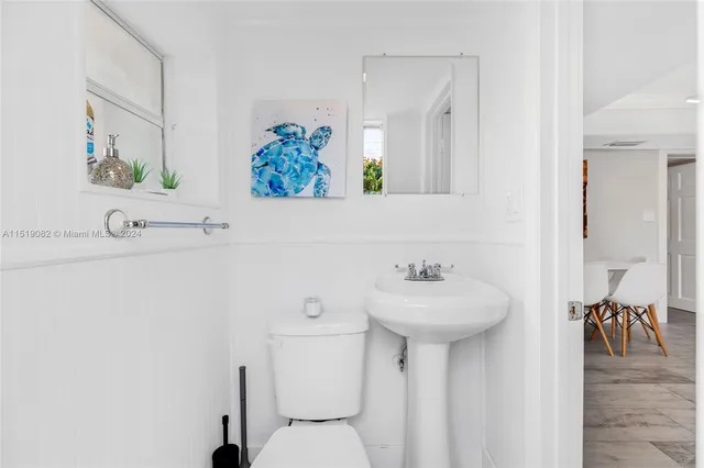 a bathroom with a sink mirror and toilet
