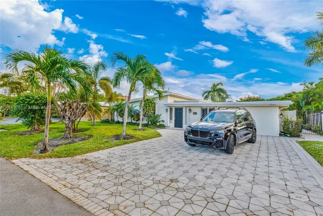 a front view of a house with garden and sitting area