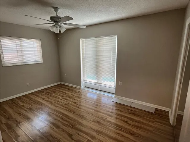 a view of a hallway with wooden floor and a window