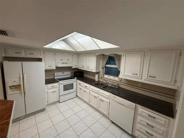 a kitchen with stainless steel appliances a sink a stove a microwave and cabinets