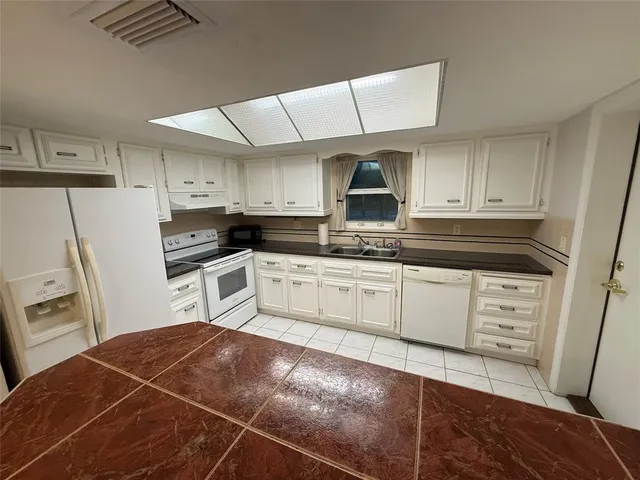 a kitchen with white cabinets and white appliances