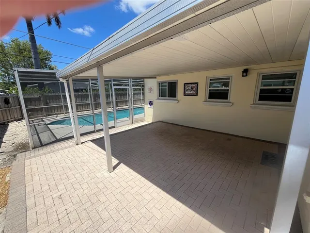 a view of an empty room with wooden floor and windows