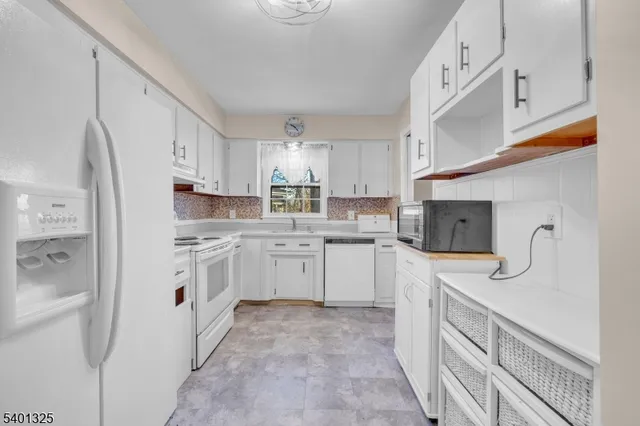 a kitchen with stainless steel appliances granite countertop a refrigerator sink and white cabinets