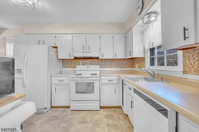 a view of kitchen with stainless steel appliances granite countertop a refrigerator and a stove top oven