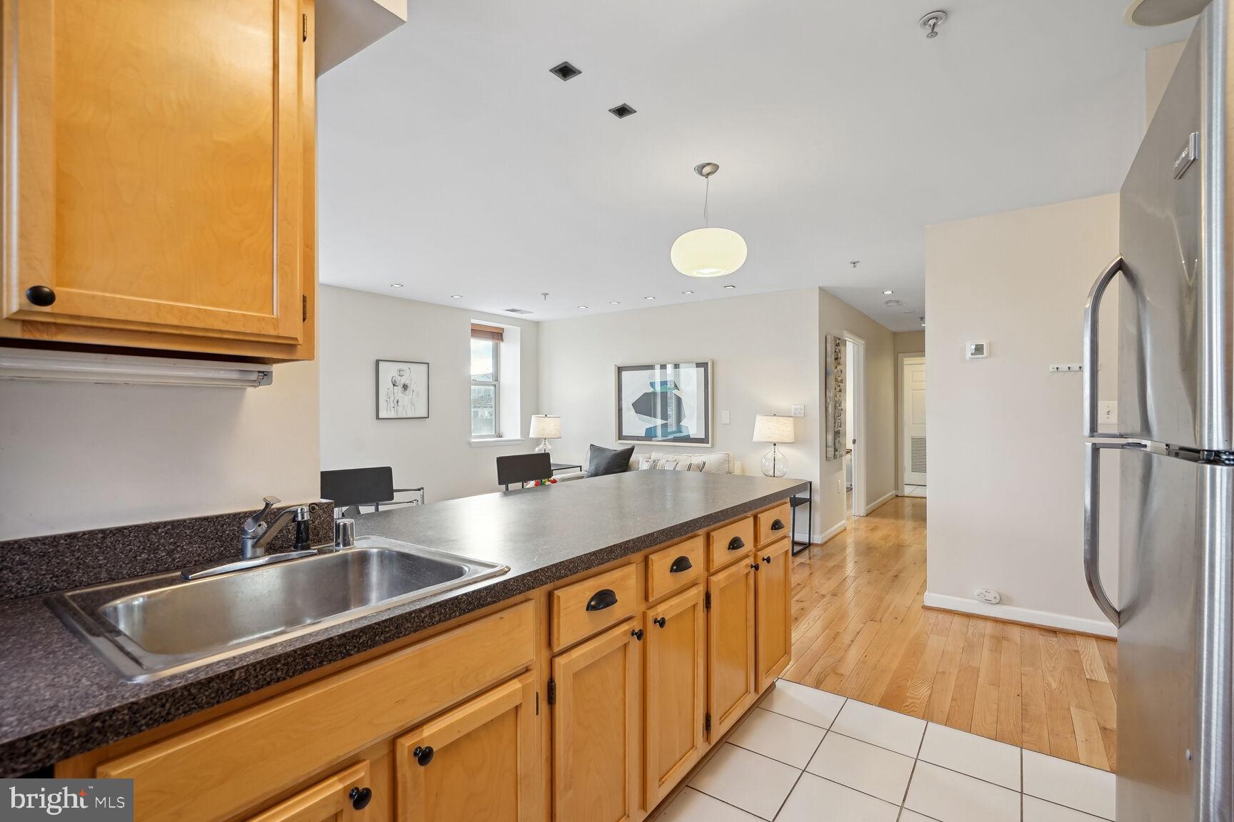 1308 Clifton Street Northwest, Unit 104 Washington, DC 20009 - Photo 11 of 24 a kitchen with stainless steel appliances granite countertop a sink and a refrigerator