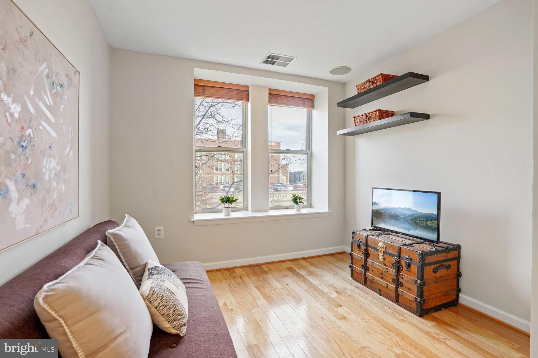 1308 Clifton Street Northwest, Unit 104 Washington, DC 20009 - Photo 15 of 24 a living room with furniture and a flat screen tv