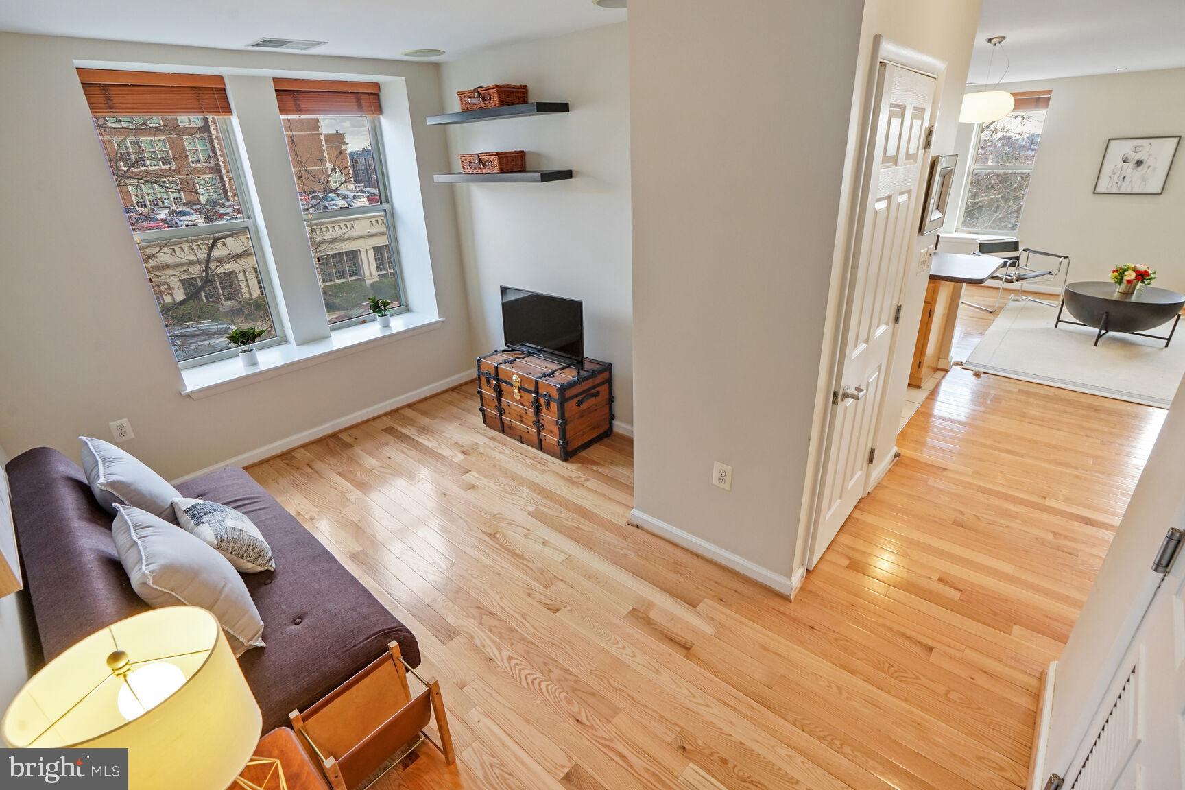 1308 Clifton Street Northwest, Unit 104 Washington, DC 20009 - Photo 17 of 24 a view of a livingroom with furniture wooden floor windows and a flat screen tv