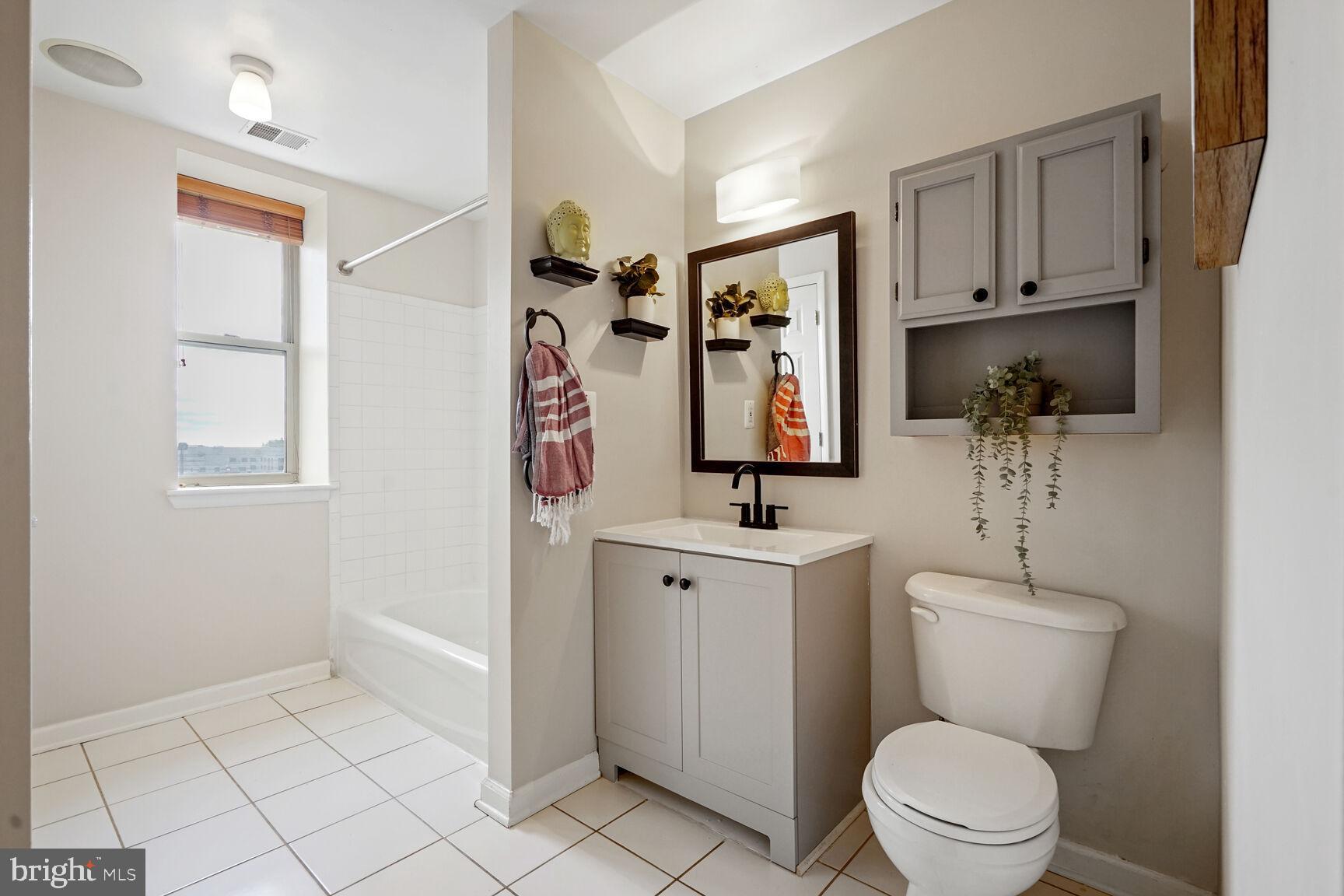 1308 Clifton Street Northwest, Unit 104 Washington, DC 20009 - Photo 18 of 24 a bathroom with a toilet sink and mirror