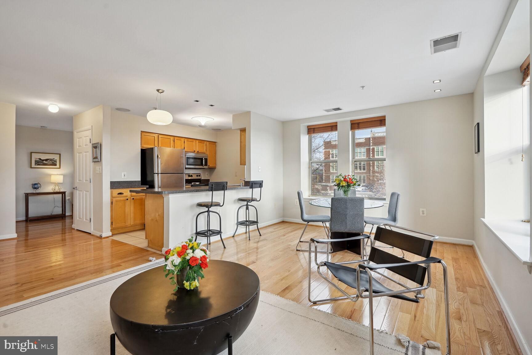 1308 Clifton Street Northwest, Unit 104 Washington, DC 20009 - Photo 2 of 24 a living room with furniture a flat screen tv and kitchen view