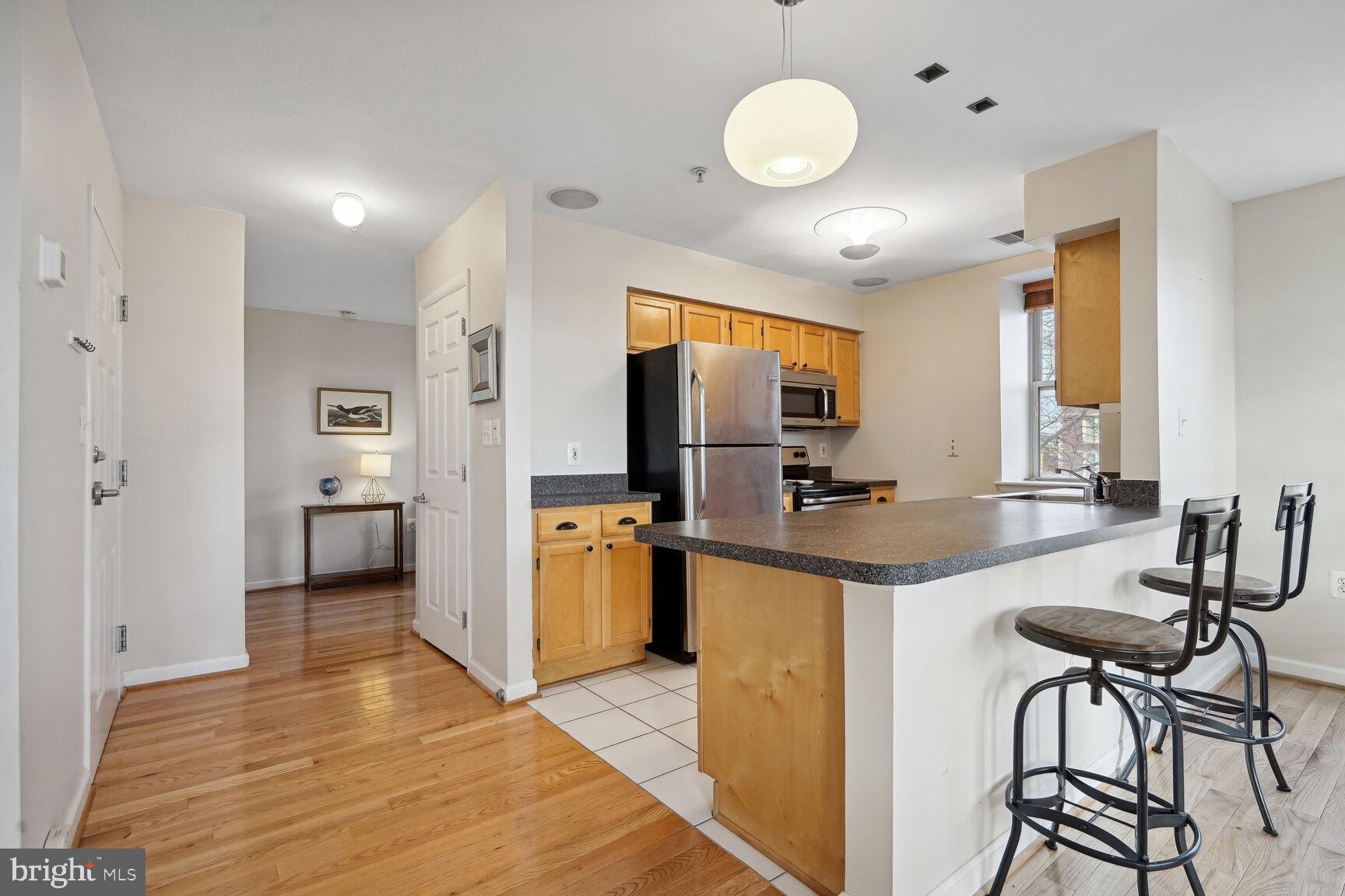 1308 Clifton Street Northwest, Unit 104 Washington, DC 20009 - Photo 8 of 24 a kitchen with stainless steel appliances granite countertop a sink and a refrigerator