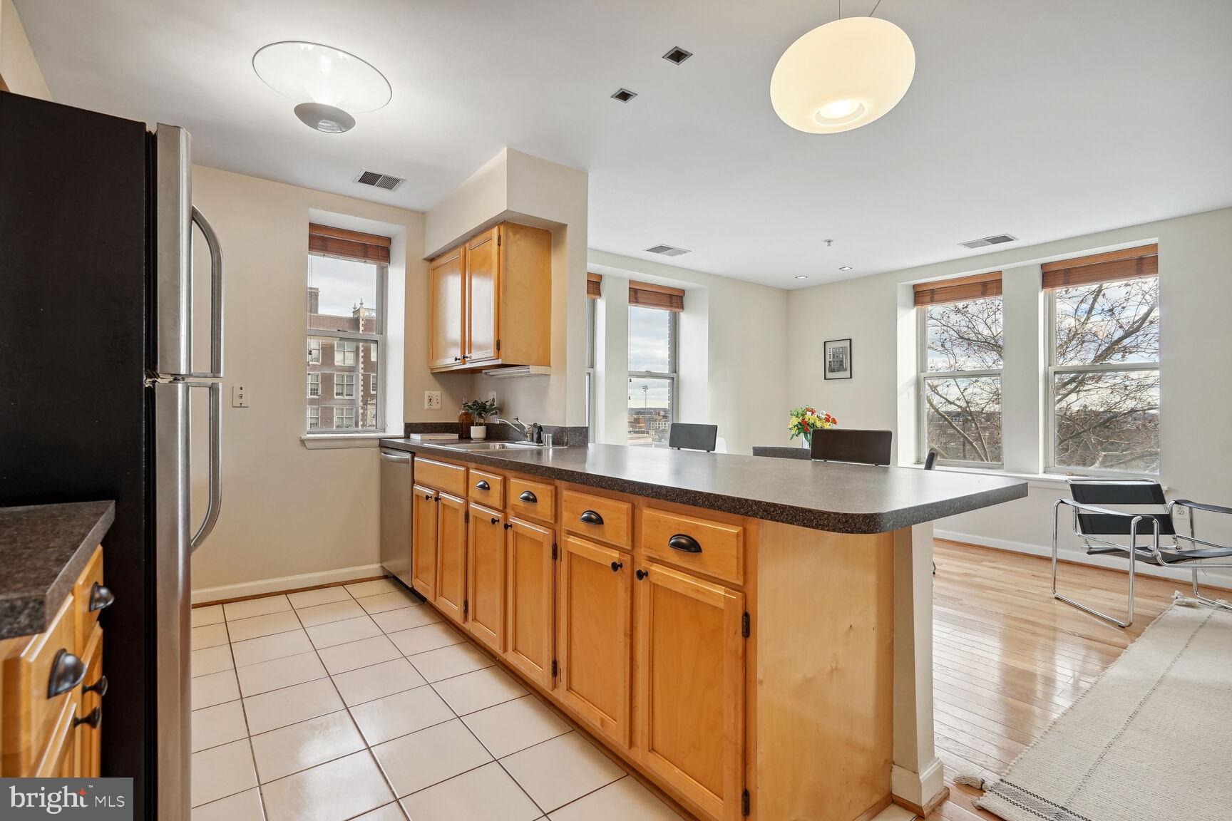 1308 Clifton Street Northwest, Unit 104 Washington, DC 20009 - Photo 9 of 24 a large kitchen with a large window and stainless steel appliances