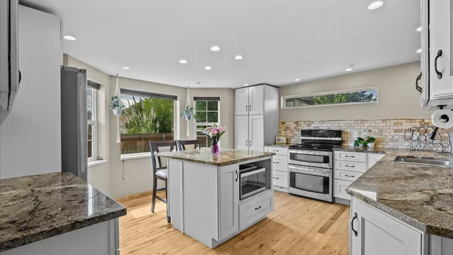 a kitchen with stainless steel appliances granite countertop a stove oven and a refrigerator