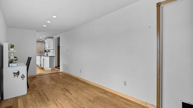 a view of a kitchen with refrigerator and wooden floor
