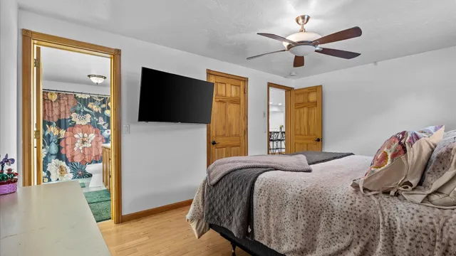 a bedroom with a bed and a flat tv screen on dresser