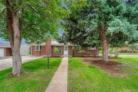 a front view of a house with yard and tree