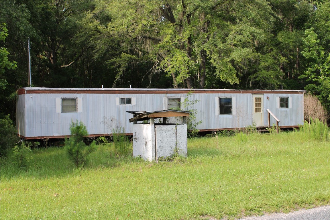 481218 Haddock Road Hilliard, FL 32046 - Photo 26 of 27 a view of a backyard with barn and yard