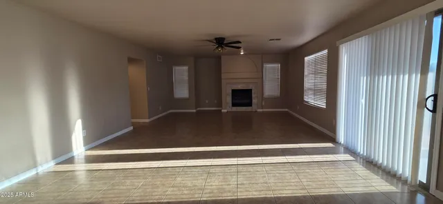 a view of an empty room with fireplace and a window