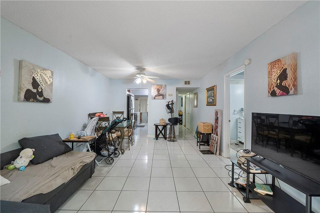 7401 Northwest 16th Street, Unit 103 Plantation, FL 33313 - Photo 3 of 12 a living room with furniture and a fireplace