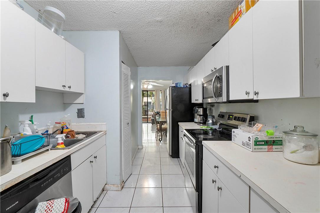 7401 Northwest 16th Street, Unit 103 Plantation, FL 33313 - Photo 4 of 12 a kitchen with stainless steel appliances granite countertop a sink stove and cabinets
