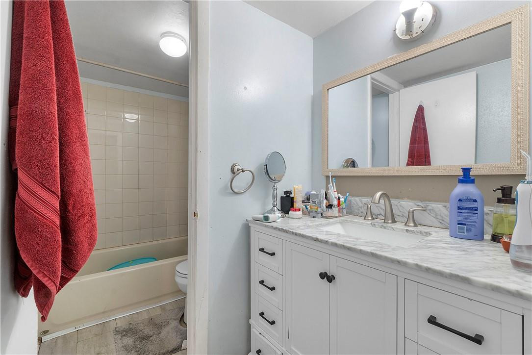7401 Northwest 16th Street, Unit 103 Plantation, FL 33313 - Photo 8 of 12 a bathroom with a sink mirror and vanity