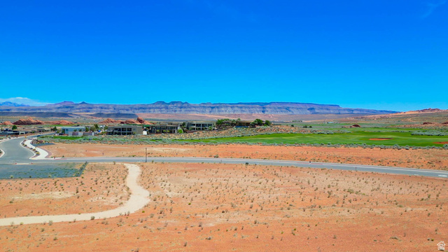 3306 South Endless Trail, Unit 33 Hurricane, UT 84737 - Photo 25 of 27 Expansive desert landscape featuring a paved road, winding dirt path, and distant residential structures