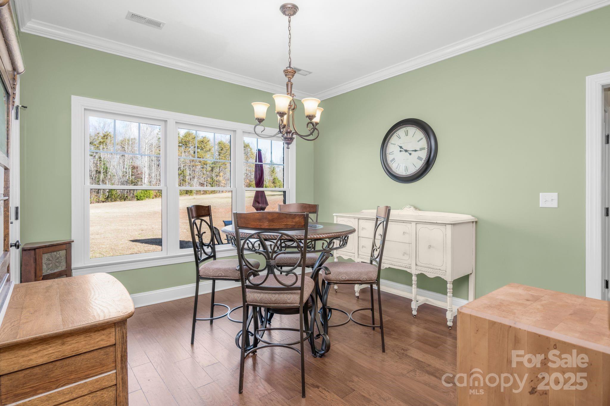 476 Ijames Church Road Mocksville, NC 27028 - Photo 13 of 48 a dining room with wooden floor a chandelier a wooden table and chairs