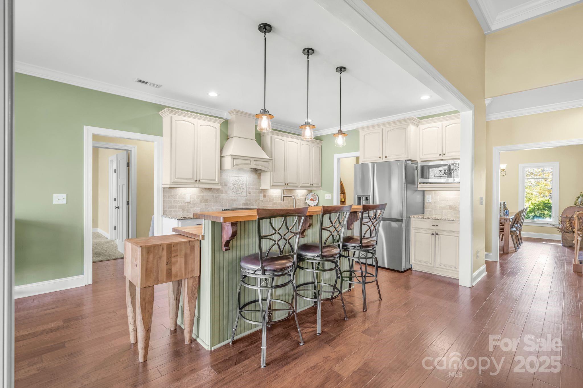 476 Ijames Church Road Mocksville, NC 27028 - Photo 8 of 48 a kitchen with stainless steel appliances kitchen island wooden floors refrigerator and dining table
