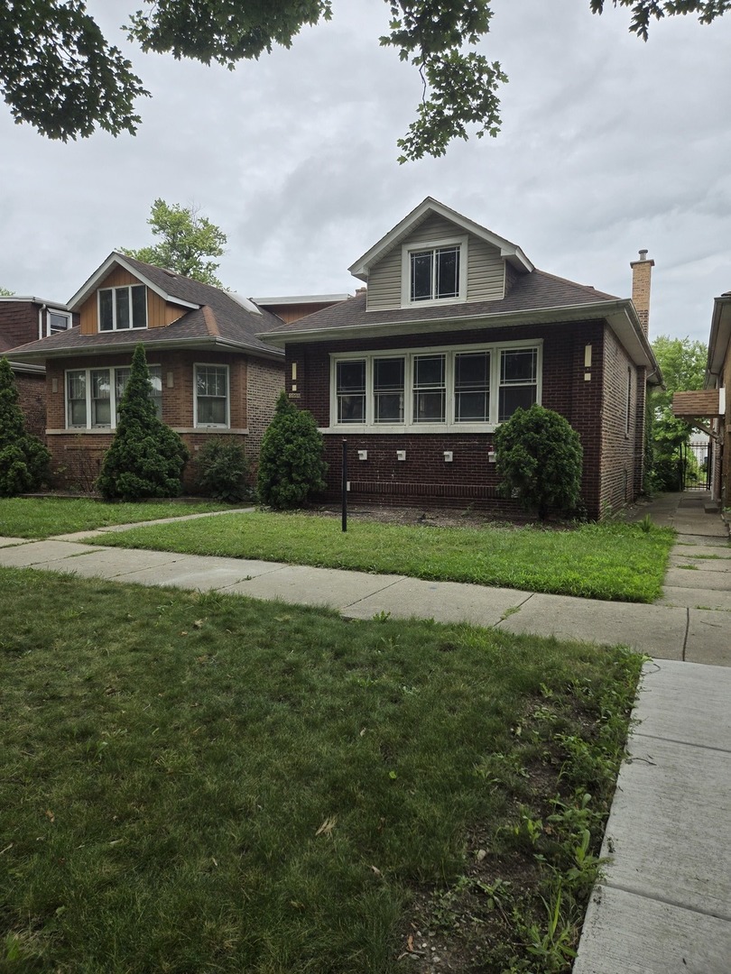 8220 South Prairie Avenue Chicago, IL 60619 - Photo 1 of 2 a front view of a house with a yard