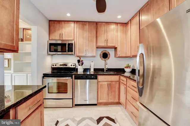 a kitchen with stainless steel appliances granite countertop a refrigerator sink and stove