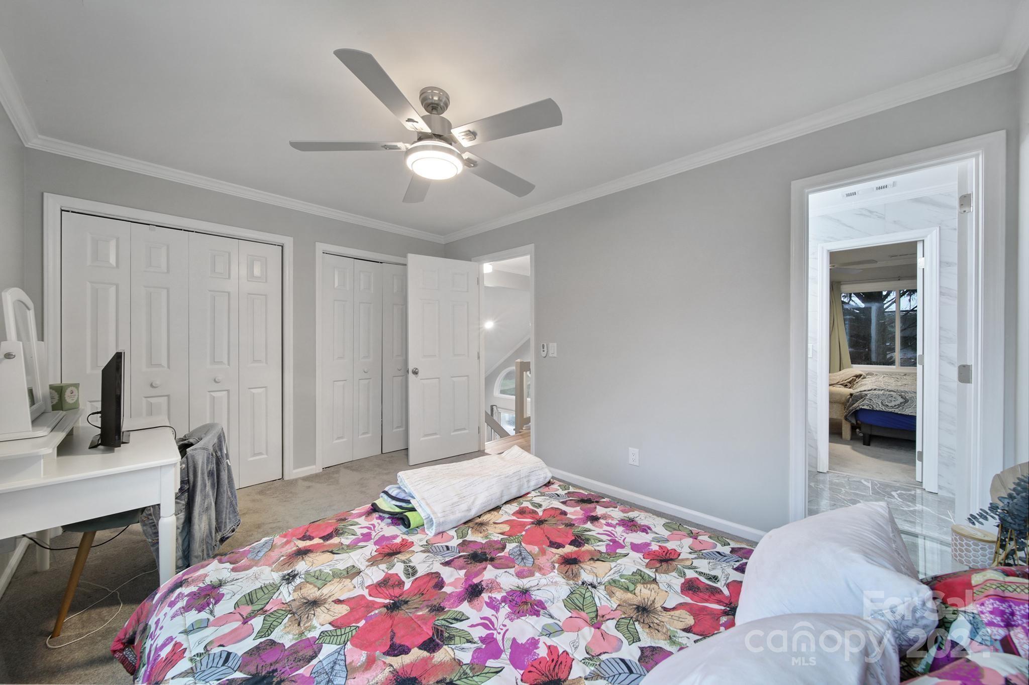 9119 Windjammer Drive Tega Cay, SC 29708 - Photo 17 of 40 a bedroom with a bed and a chandelier