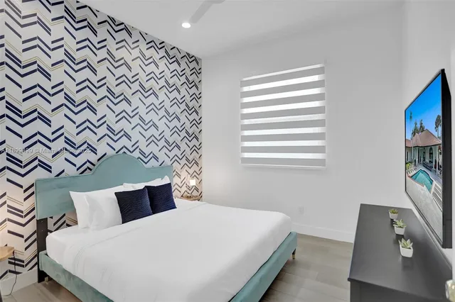 a bedroom with a bed and a flat screen tv