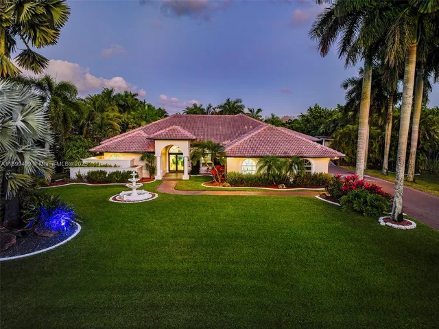 a view of a swimming pool with lawn chairs under an umbrella