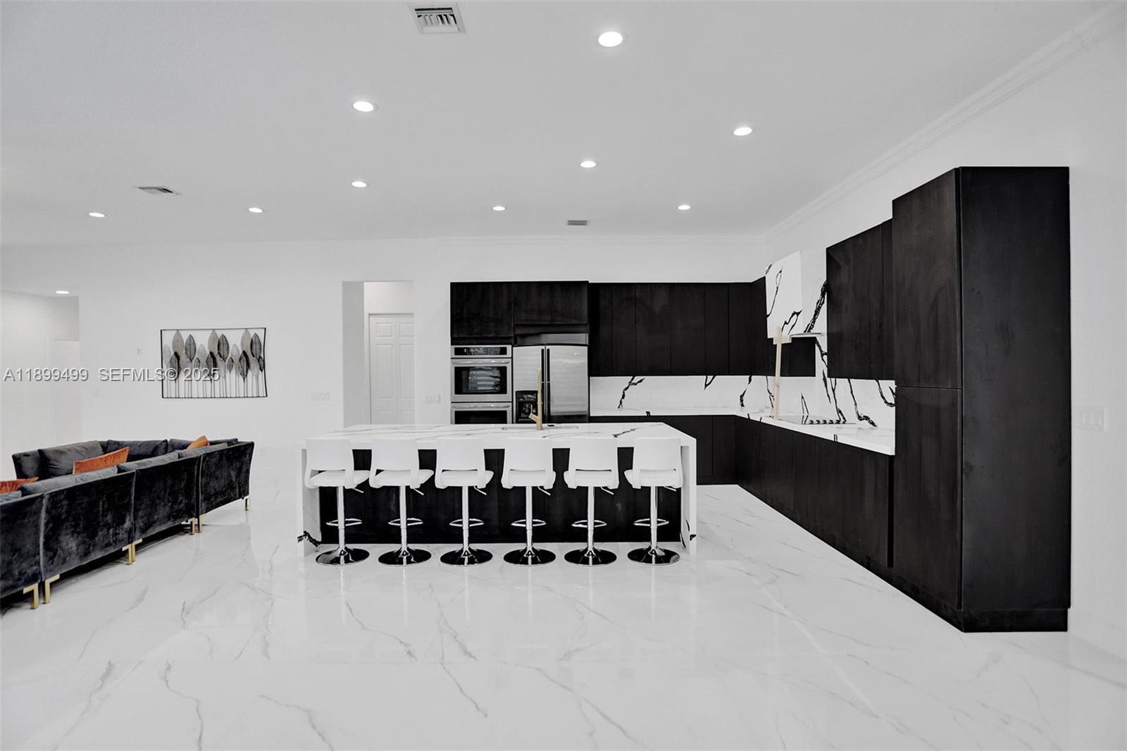 3152 Southwest 147th Avenue Davie, FL 33330 - Photo 8 of 38 a kitchen with stainless steel appliances kitchen island granite countertop a refrigerator and a sink
