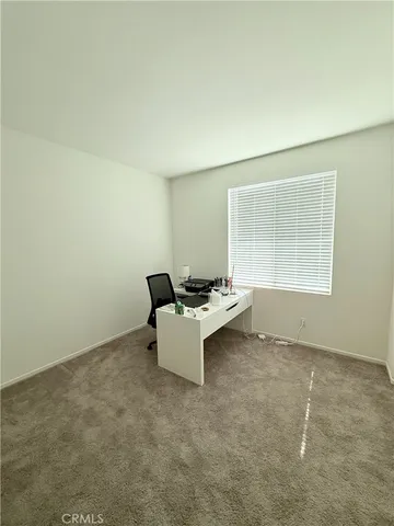 a view of a room with a white wall and a window