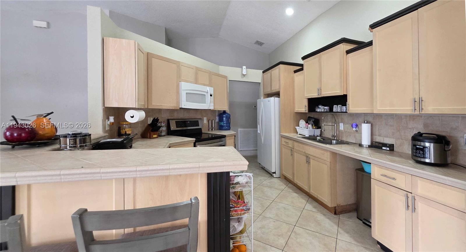 355 North Lindero Street Clewiston, FL 33440 - Photo 18 of 30 a kitchen with a stove a sink and a refrigerator
