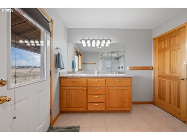 a bathroom with a granite countertop sink a mirror and a shower