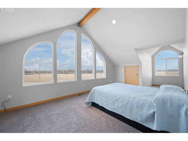 a bedroom with a bed and a large window
