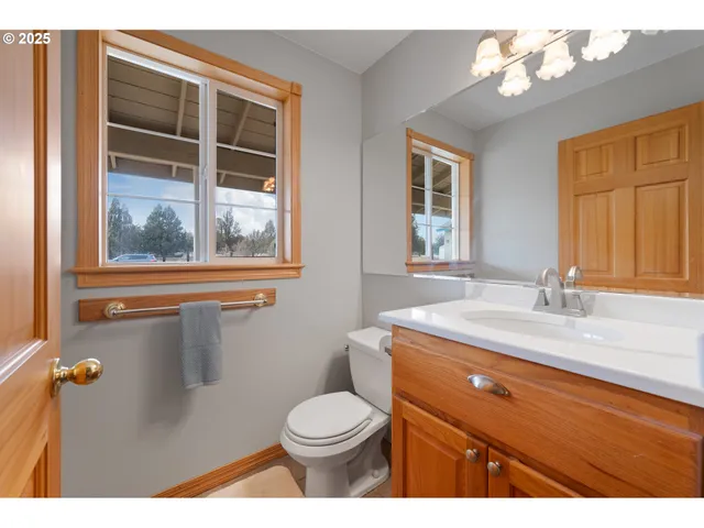 a bathroom with a sink a toilet and a window