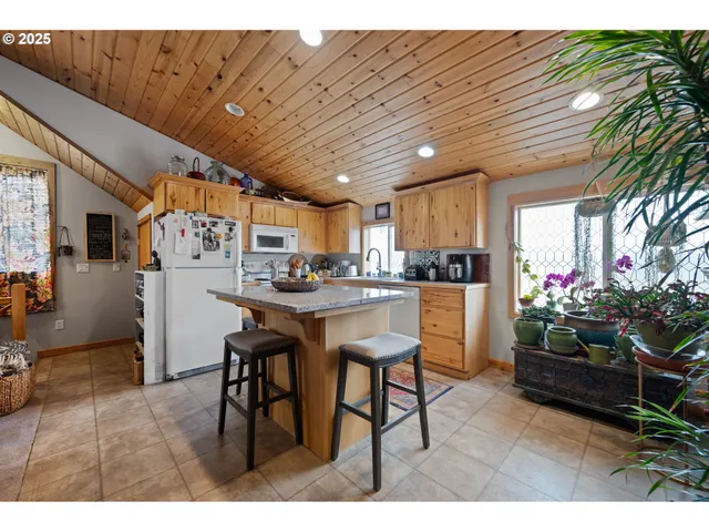 a kitchen with stainless steel appliances kitchen island granite countertop a refrigerator a stove a sink dishwasher with a dining table and chairs