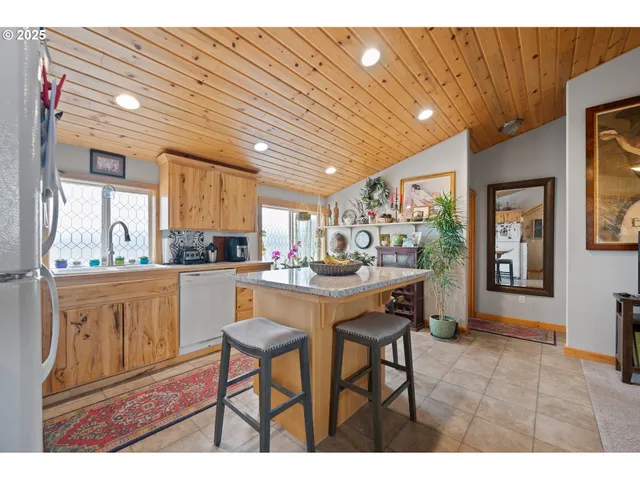 a kitchen with stainless steel appliances granite countertop table chairs sink and cabinets