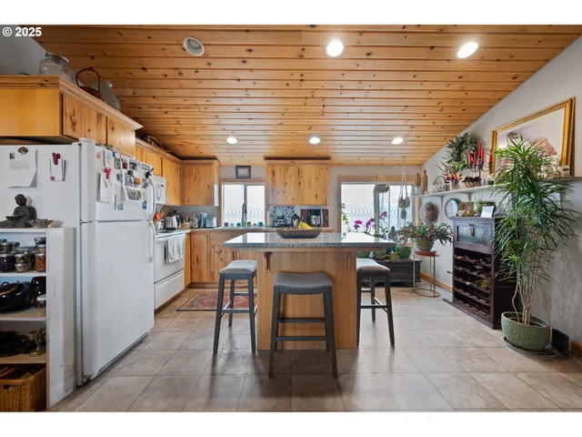 a kitchen with stainless steel appliances granite countertop a refrigerator and chairs